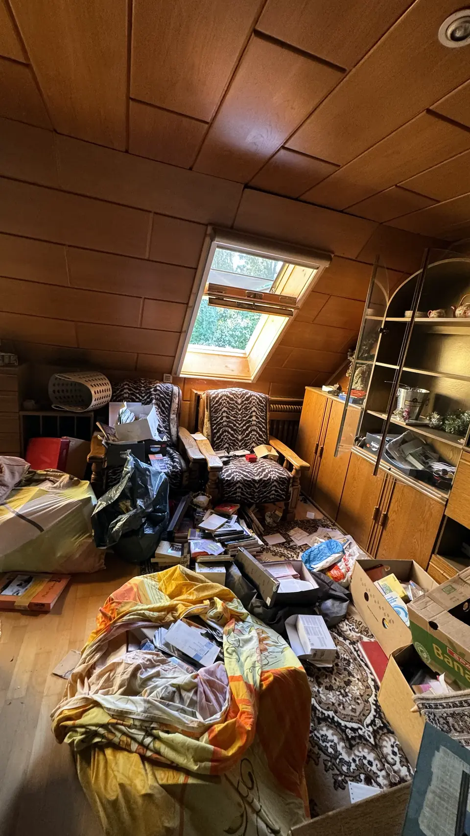 Dachgeschoß mit Sesseln, Kartons und Hausrat vor der Räumung