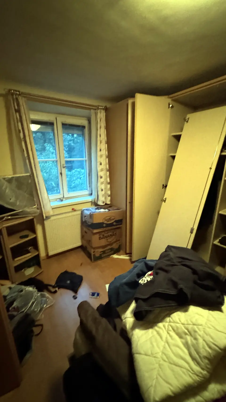 Schlafzimmer mit offenem Kasten während der Räumung