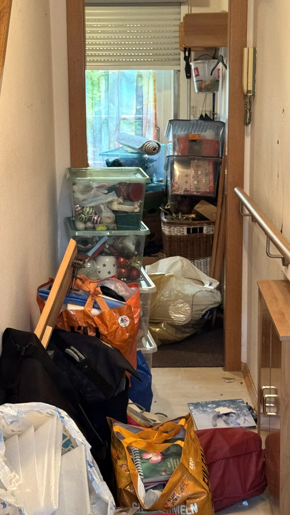 Gang mit gestapelten Boxen, Körben und Säcken